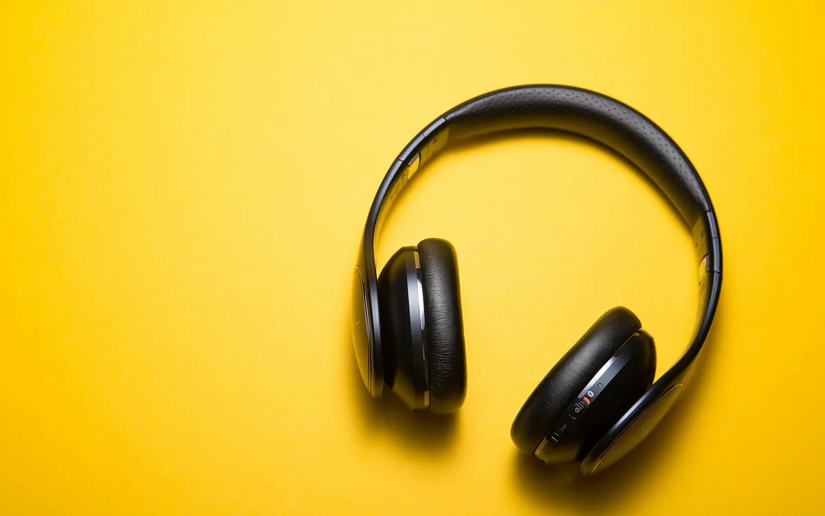 Placeholder: black headphones on a yellow background.
