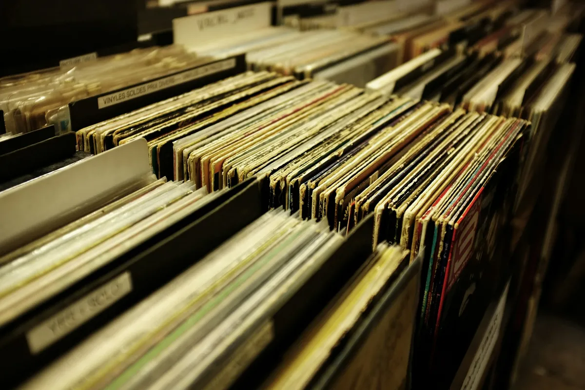 Placeholder: rows of vinyl records in crates at a record shop.