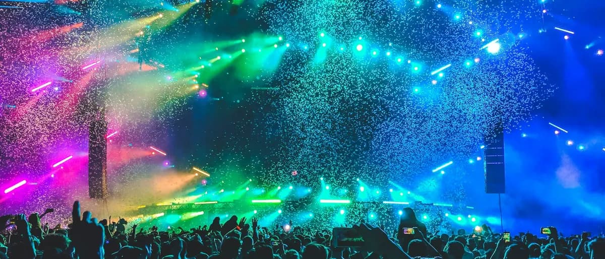 Placeholder: a crowd at a festival under colourful lights.