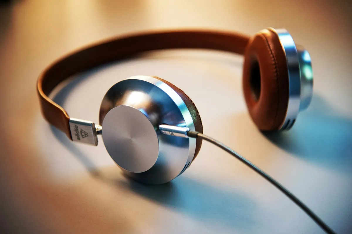 Placeholder: silver and tan headphones resting on a table.