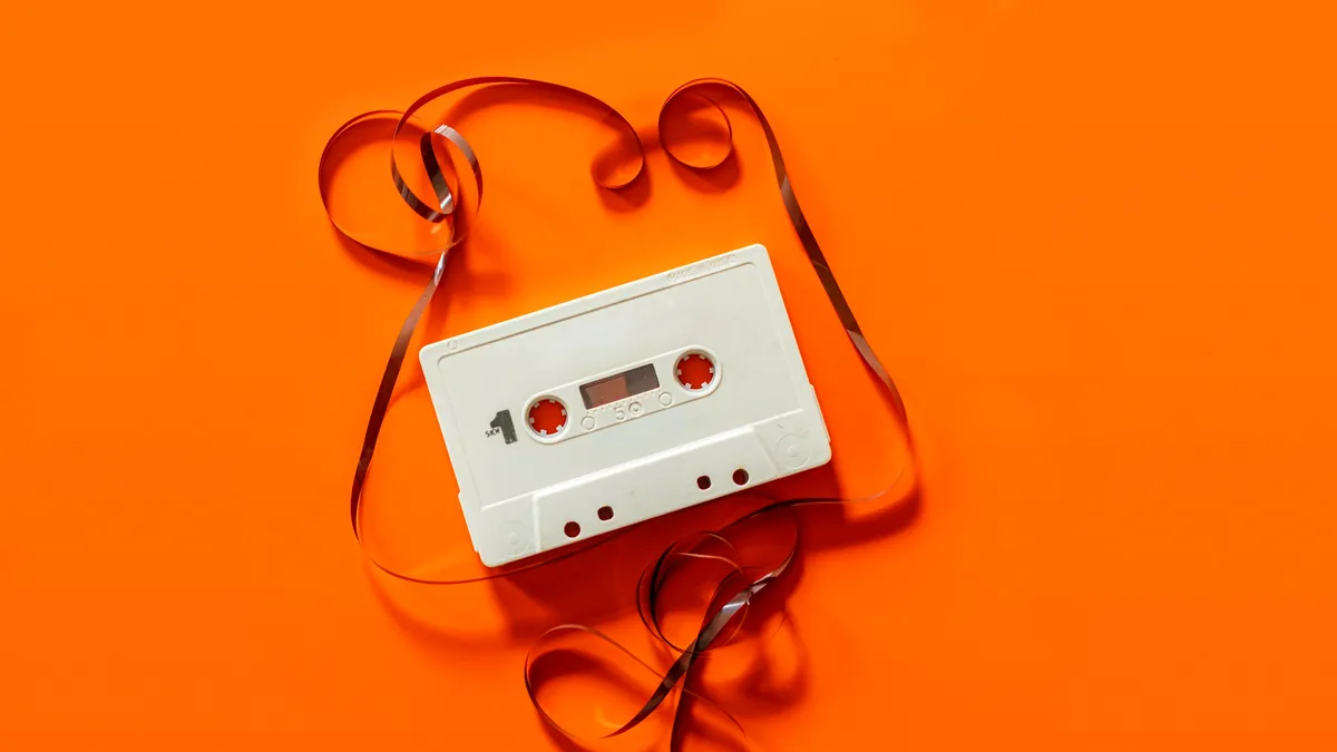 Placeholder: a white cassette tape on an orange background.