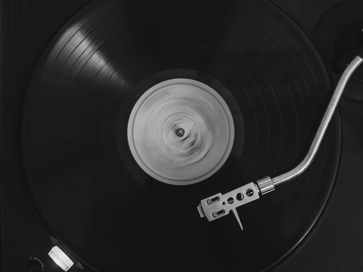 Placeholder: a record spinning on a turntable, in black and white.