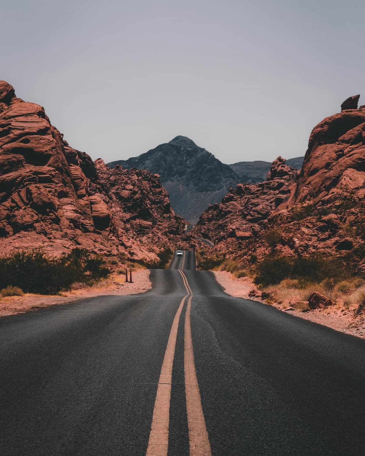 Placeholder: an empty road through red rock hills.