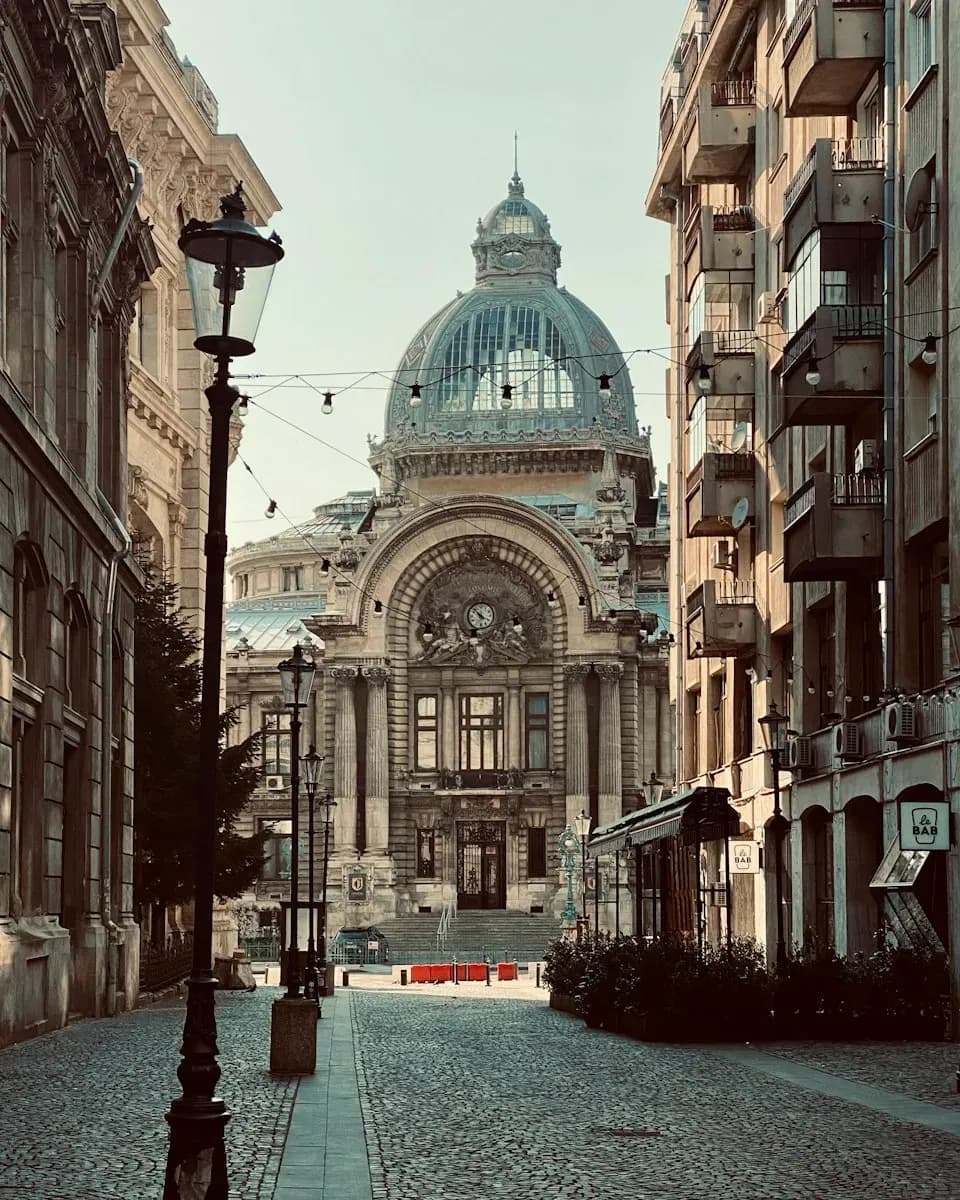 A cobbled street in Bucharest leading to a domed building.