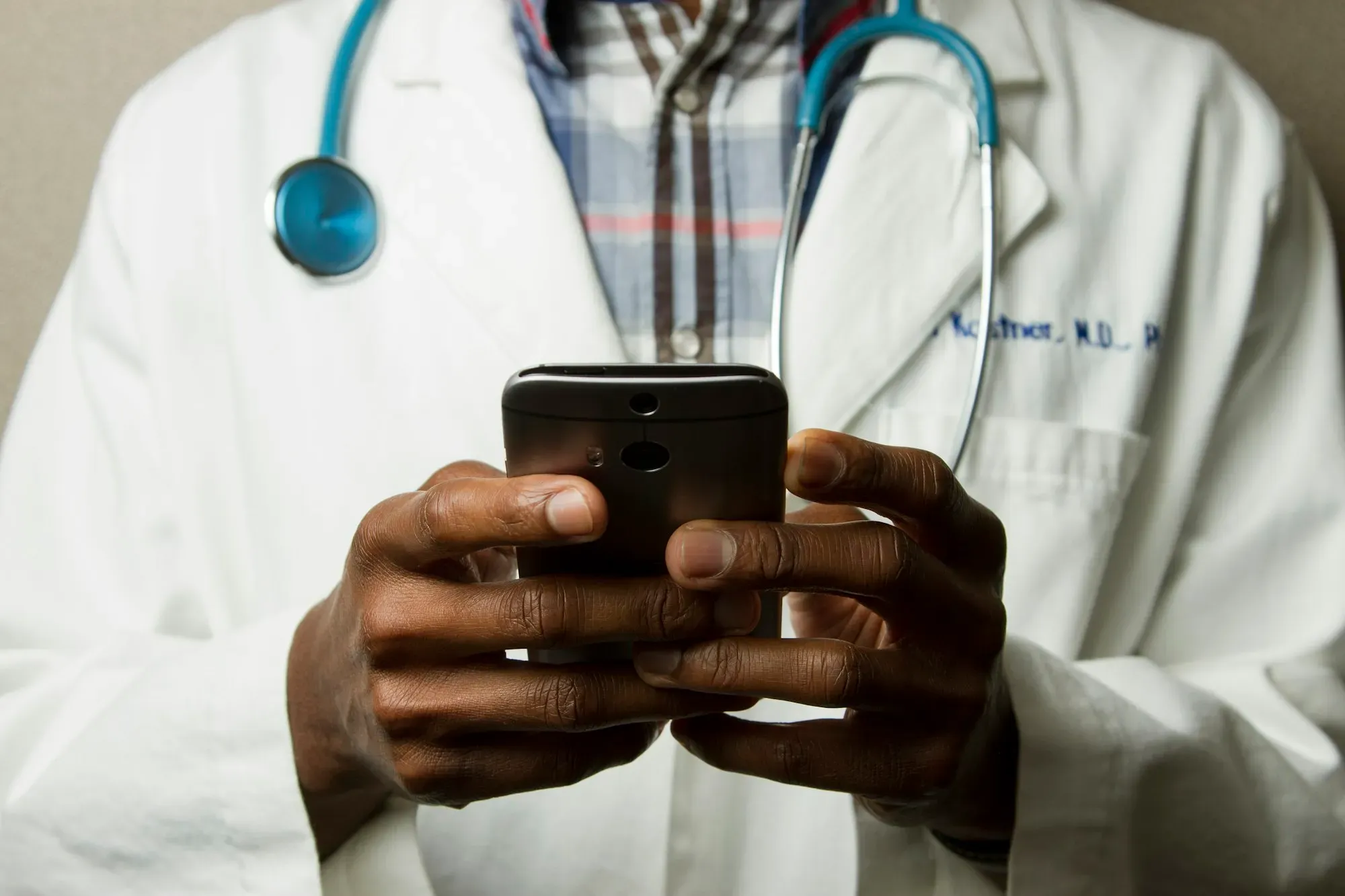 Placeholder: a doctor holding a smartphone.